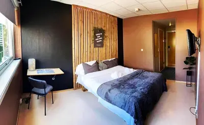 a bedroom with a bed and a table and a chair at Gjøvik Overnatting in Gjøvik