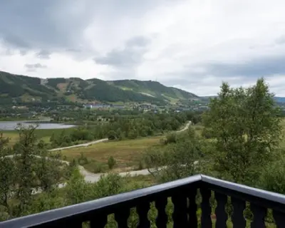 a balcony with a view of a river and mountains at Vestlia Ski in Geilo