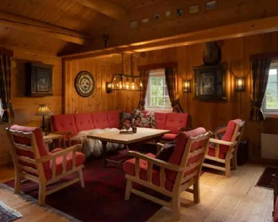 a living room with a red couch and a table and chairs at Vestlia Ski in Geilo