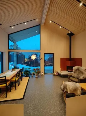 a living room with a table and chairs and a large window at Huset ved skogen in Isfjorden