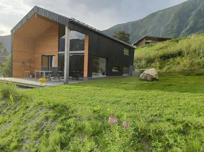 a house on a hill with a green yard at Huset ved skogen in Isfjorden