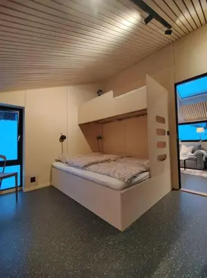 a room with a bunk bed with a large screen at Huset ved skogen in Isfjorden