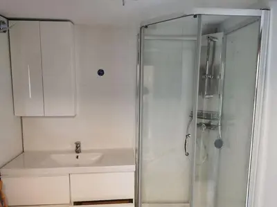 a white bathroom with a shower and a sink at Rekdal in Vestnes