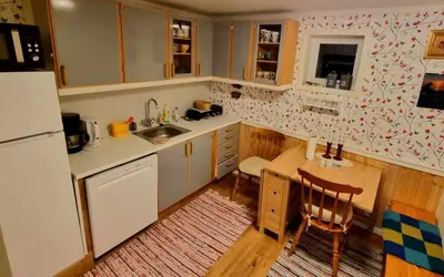 a small kitchen with a table and a refrigerator at Rekdal in Vestnes