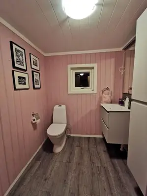 a pink bathroom with a toilet and a sink at Rekdal in Vestnes