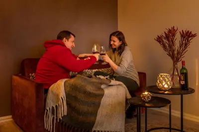 a man and woman sitting at a table with wine glasses at Skåbu Fjellhotell in Skåbu