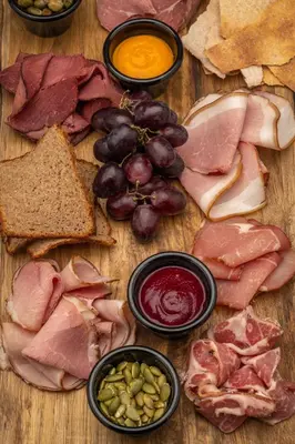 a wooden table topped with different types of meat and vegetables at Skåbu Fjellhotell in Skåbu