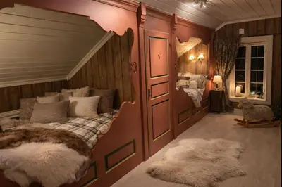 a bedroom with a large bed with two rugs at Traditional timber farm with Sauna & Wi-Fi in Baukål