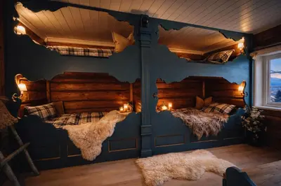 two beds in a room with blue walls at Traditional timber farm with Sauna & Wi-Fi in Baukål