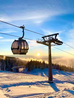 a ski lift with people on it in the snow at New ski in-out apartment with sauna in Hafjell in Øyer