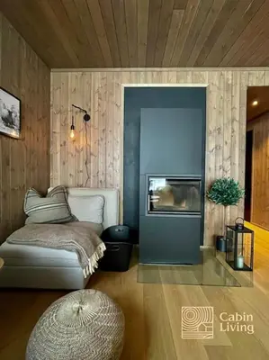 a living room with a couch and a fireplace at New ski in-out apartment with sauna in Hafjell in Øyer