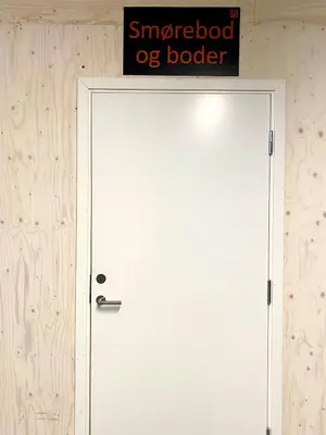 a white door with a sign on top of it at New ski in-out apartment with sauna in Hafjell in Øyer