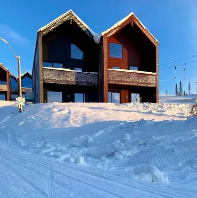 a building in the snow with a pile of snow at New ski in-out apartment with sauna in Hafjell in Øyer