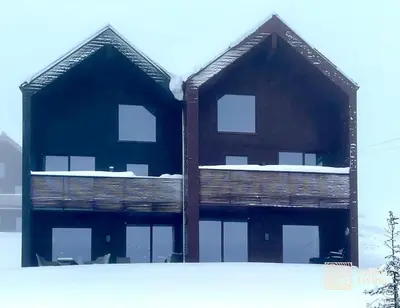 a building with windows on the side of it at New ski in-out apartment with sauna in Hafjell in Øyer