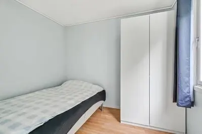 a bedroom with a bed and a white cabinet at Fully equipped independent apartment near NTNU,Lerkendal og center in Trondheim