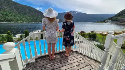 two girls standing on a bridge overlooking a body of water at Hofslund Apartments in Sogndal