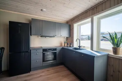 a kitchen with black cabinets and a sink at Bjorli Fjellstuer - by Classic Norway Hotels in Bjorli