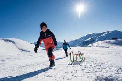 a young boy playing in the snow with a sled at Loen Apartments in Loen