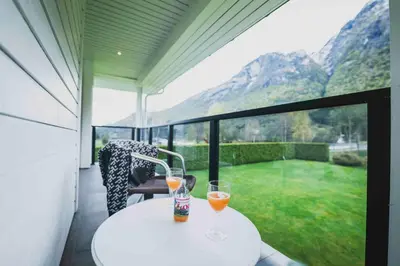 two glasses of orange juice sitting on a table on a balcony at Loen Apartments in Loen