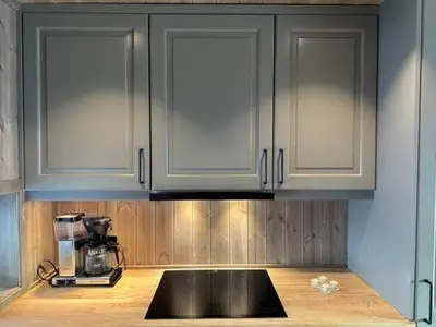 a kitchen with white cabinets and a black counter top at Aurdalsåsen panorama in Aurdal