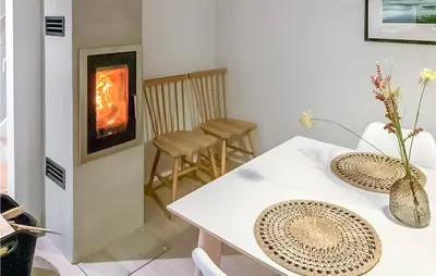 a living room with a table and a fireplace at 3 Bedroom Lovely Home In Hebnes in Hebnes