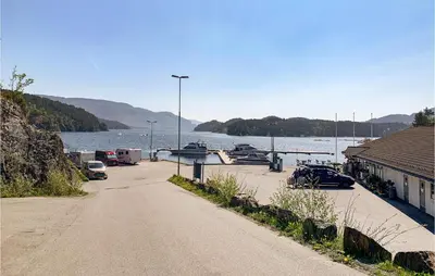 a dirt road next to a body of water with boats at 3 Bedroom Lovely Home In Hebnes in Hebnes