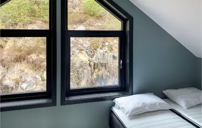 a bed in a room with two windows at Amazing Home In Hebnes With Wifi in Hebnes
