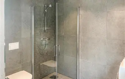 a glass shower stall with a toilet in a bathroom at Amazing Home In Hebnes With Wifi in Hebnes