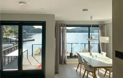 a dining room with a table and a view of the water at Amazing Home In Hebnes With Wifi in Hebnes
