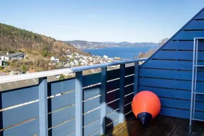 a orange ball on a balcony with a view of the water at Cosy house with sunny terrace, garden and fjord view in Bergen