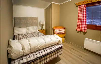 a bedroom with a bed and a chair and a window at Stunning Home In Tyinkrysset in Tyinkrysset