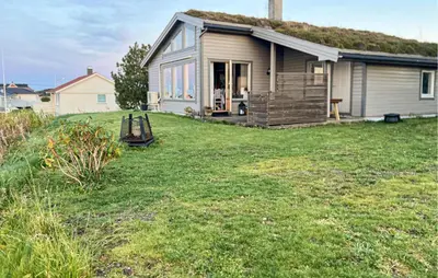 a small house with a grass roof on a yard at Cozy Home In Vevang With Sauna in Vevang