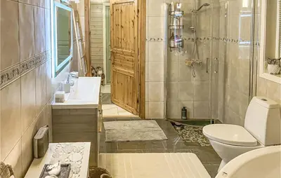 a bathroom with a toilet and a sink and a shower at Cozy Home In Vevang With Sauna in Vevang