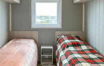 a small bedroom with a bed and a window at Lovely Home In Smøla With Kitchen in Smøla