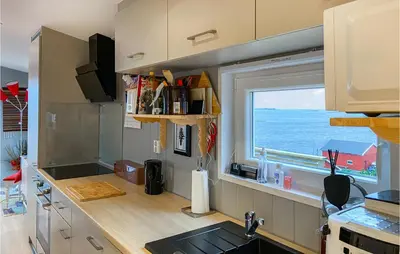 a kitchen with a view of the ocean from a window at Lovely Home In Smøla With Kitchen in Smøla