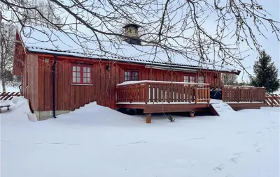 a red cabin with a deck in the snow at 3 Bedroom Lovely Home In Vinstra in Vinstra