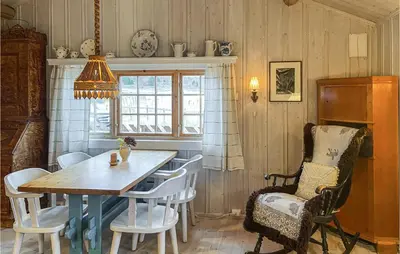 a dining room with a wooden table and chairs at 3 Bedroom Lovely Home In Vinstra in Vinstra