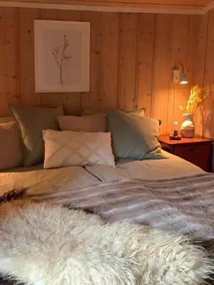 a bedroom with a bed with a furry blanket on it at Enok Hytter & Resort in Liagardane