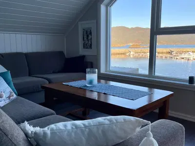 a living room with a table with a glass of milk at 6 person holiday home in Huglo-By Traum in Nordhuglo