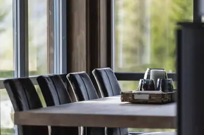 a table with chairs and a phone on top of it at Moderne ski-in & ski-out hytte i Valdres, Norge - alt inkludert for ditt fjelleventyr in Aurdal