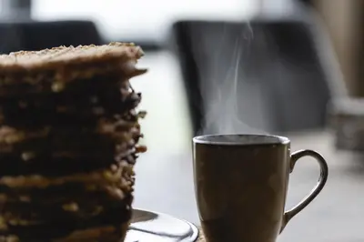 a piece of cake next to a cup of coffee at Moderne ski-in & ski-out hytte i Valdres, Norge - alt inkludert for ditt fjelleventyr in Aurdal