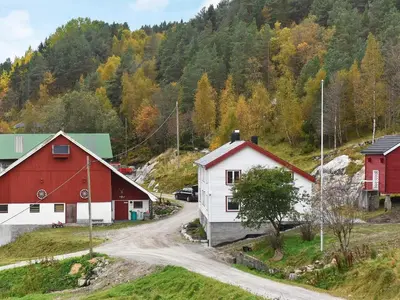a village with red and white buildings and a dirt road at 8 person holiday home in Snillfjord-By Traum in Snillfjord