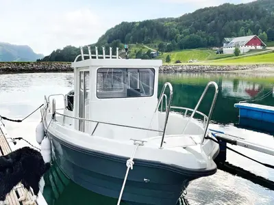 a boat is docked at a dock in the water at 8 person holiday home in Snillfjord-By Traum in Snillfjord