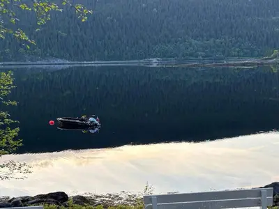 a boat is on the water in a lake at 9 person holiday home in Mosvik-By Traum in Mosvik