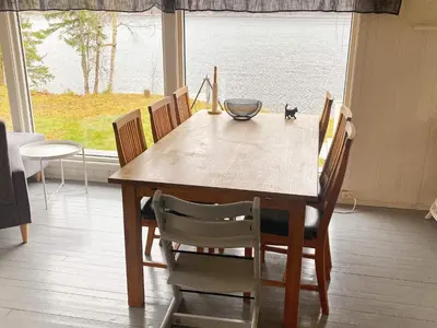 a dining room table and chairs with a view of the water at 9 person holiday home in Mosvik-By Traum in Mosvik