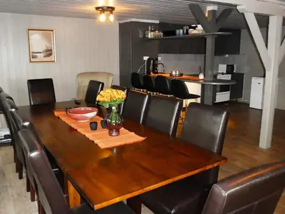 a dining room with a wooden table and leather chairs at 12 person holiday home in Selje-By Traum in Selje