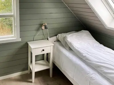 a bedroom with a bed and a nightstand with a lamp at 12 person holiday home in Selje-By Traum in Selje