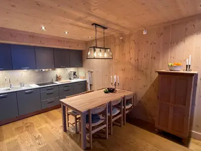 a kitchen with a wooden table and a wooden ceiling at Astonishing Mountain Lodge at the top of Gaustablikk, 25m2 west facing terrace, 3 bedrooms in Gaustablikk