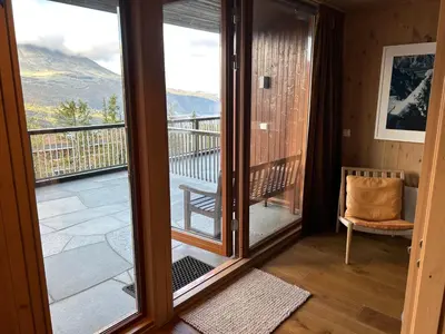 a room with a glass door leading to a balcony at Astonishing Mountain Lodge at the top of Gaustablikk, 25m2 west facing terrace, 3 bedrooms in Gaustablikk