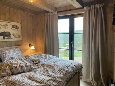 a bedroom with a bed and a large window at Beautifully styled mountain lodge with high standards, 10 minutes from Geilo in Geilo